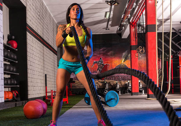 bikini competitor using battle ropes for weight loss